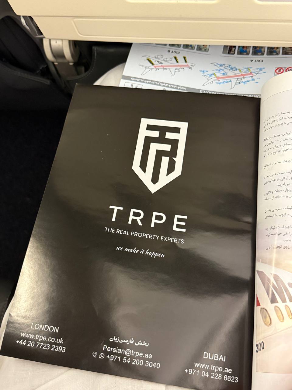 TRPE branded brochure on a London–Dubai flight — London, Farsi, and Dubai contact details, 2022